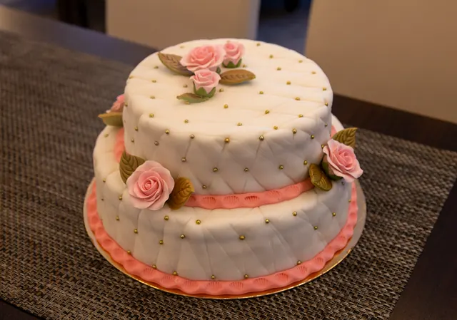 Zweistöckige Buttercremetorte mit Rosen und goldenen Zuckerperlen aus der Konditorei Soltau