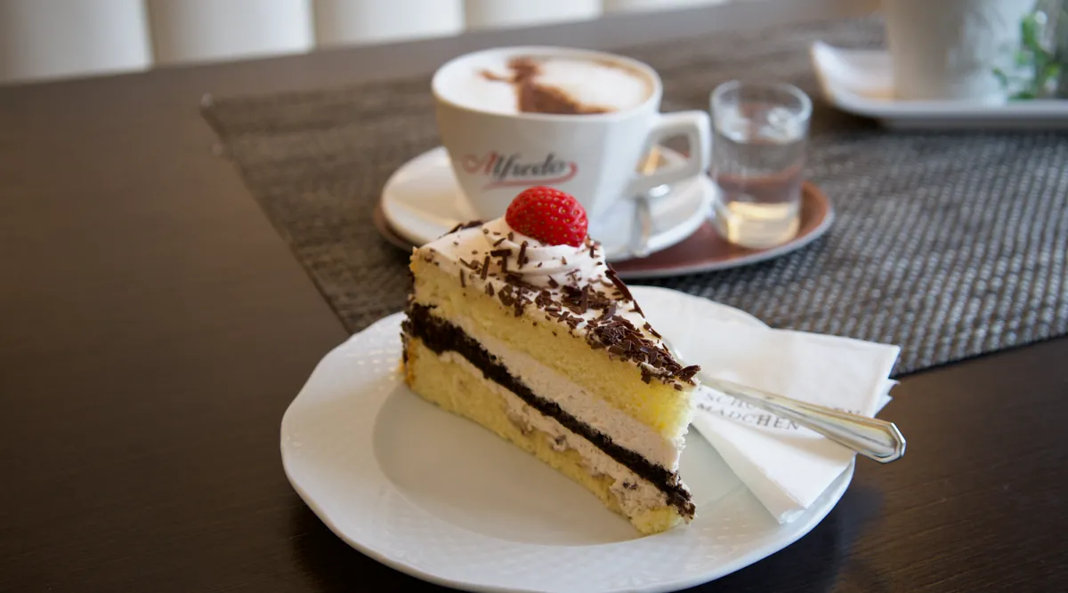 Ein Stück Torte mit Erdbeere und ein Cappuccino im Café Das Schokoladenmädchen in Soltau